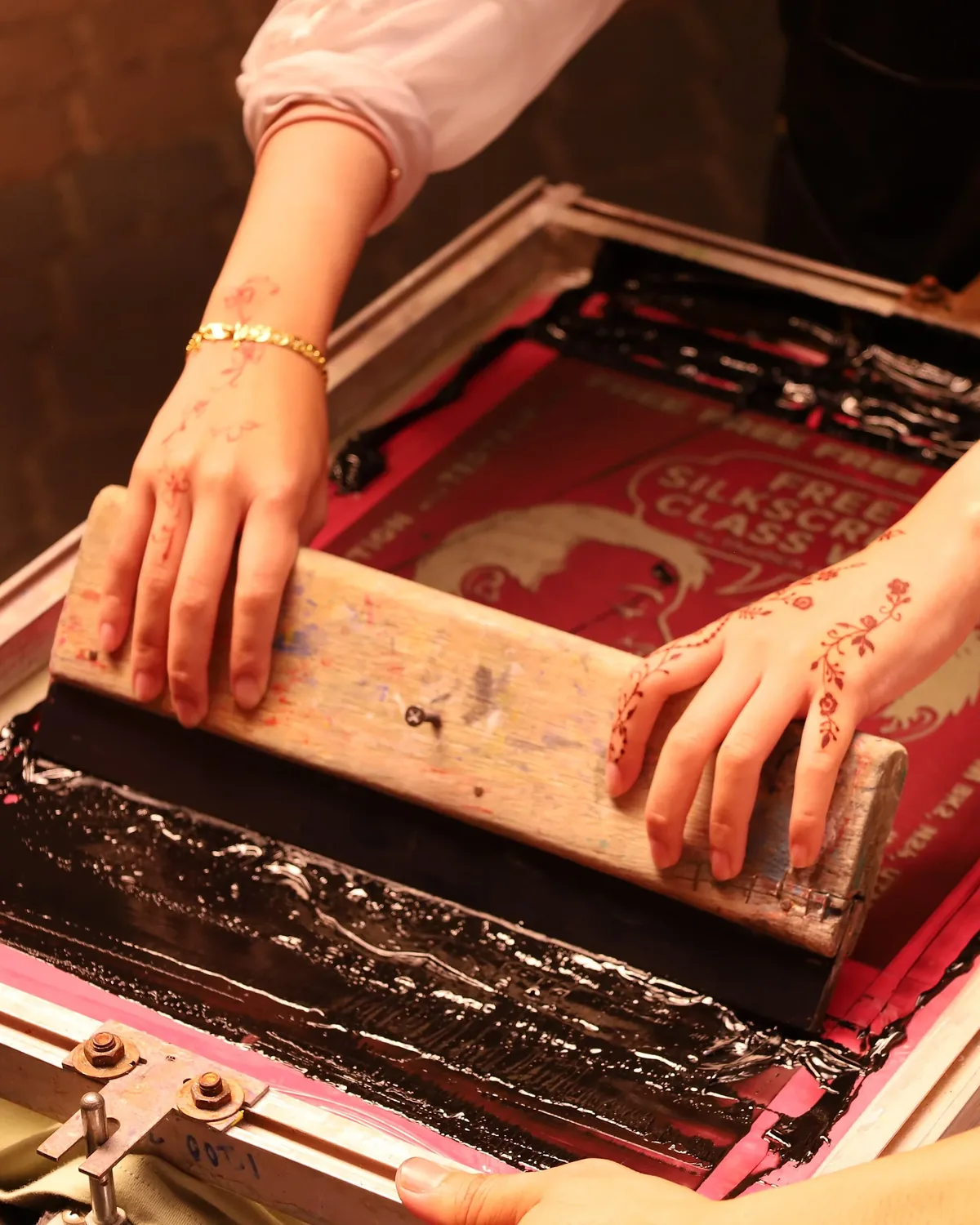 Screen printing a design by hand with a squeegee
